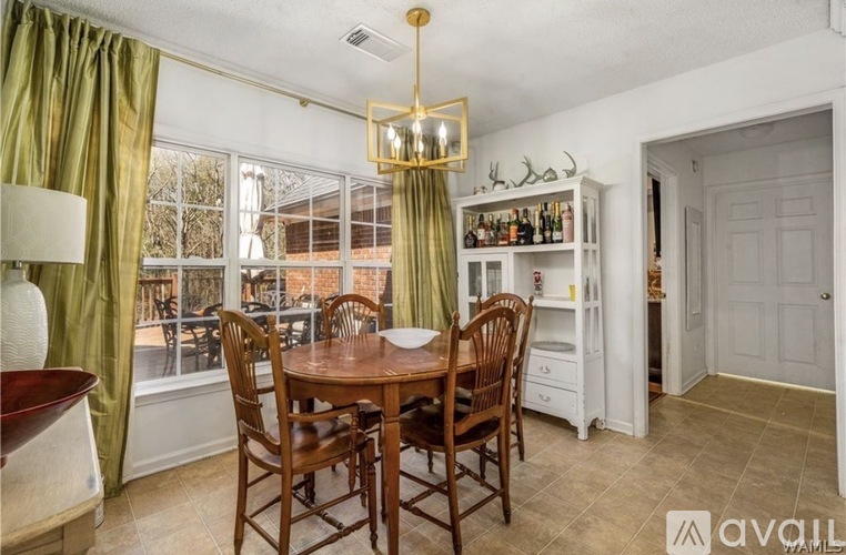 A dining room with a wooden table and chairs.