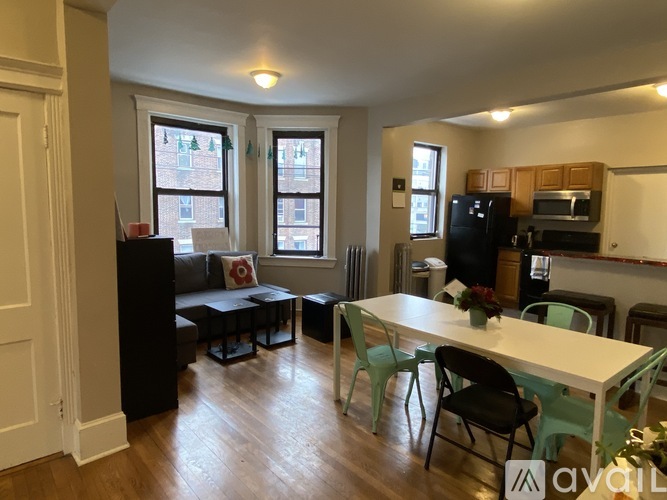 A living room with a black couch and a white dining table.