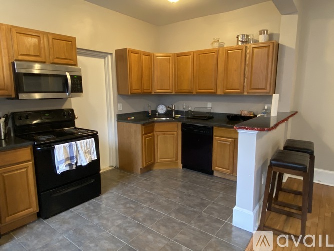 A kitchen with wooden cabinets and black appliances.