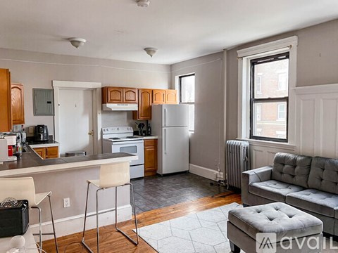 A kitchen with a refrigerator, oven, and a dining table with chairs.