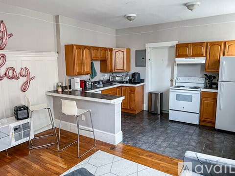 A kitchen with wooden cabinets and a white fridge.