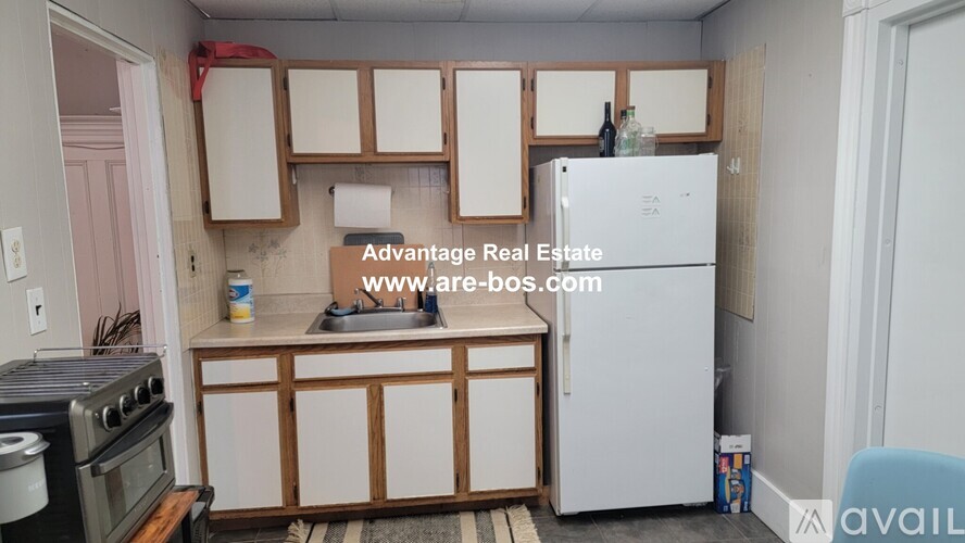 A kitchen with a white fridge and wooden cabinets.