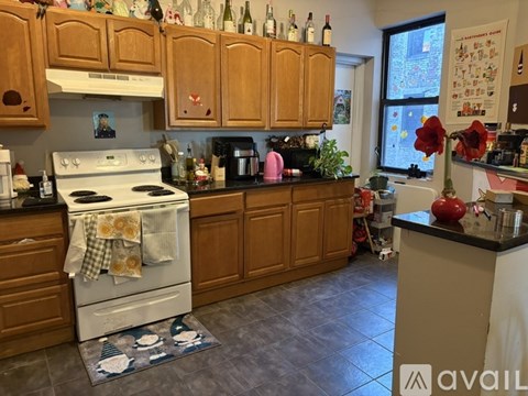 A kitchen with wooden cabinets and a white stove top oven.