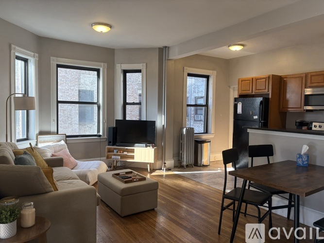 A living room with a couch, chair, and television.