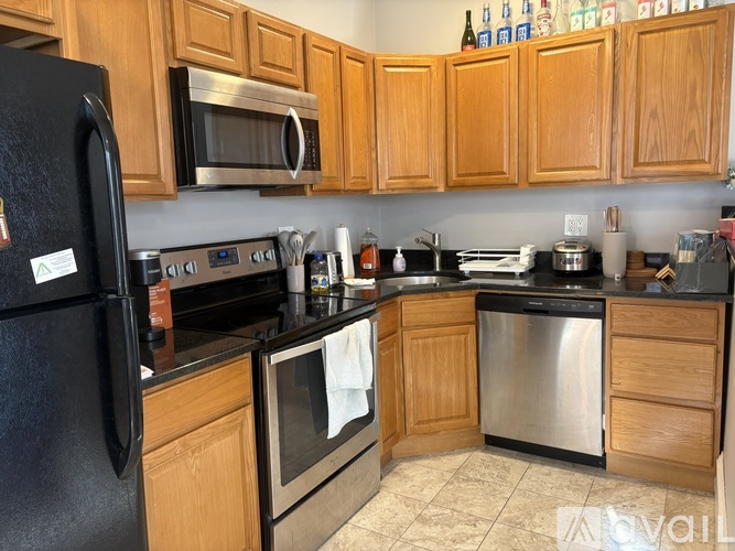 A kitchen with wooden cabinets and black appliances.