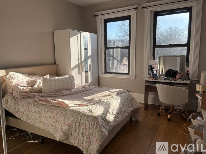 A bedroom with a bed, desk, and chair.