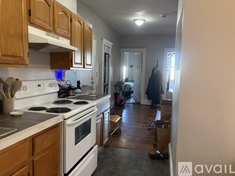 A kitchen with wooden cabinets and a white stove top oven.