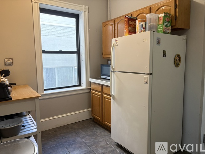 A kitchen with a white fridge and wooden cabinets.