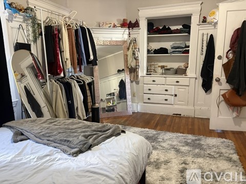 A bedroom with a bed, a wardrobe, and a rug.