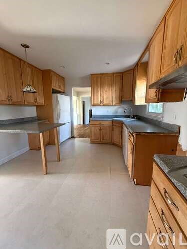 A kitchen with wooden cabinets and a black countertop.