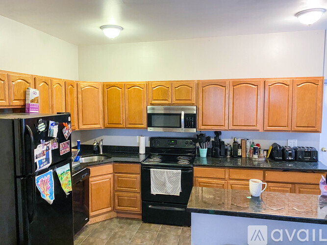 A kitchen with wooden cabinets and black appliances.