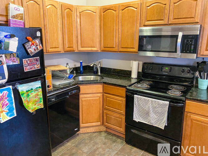 A kitchen with wooden cabinets and black appliances.