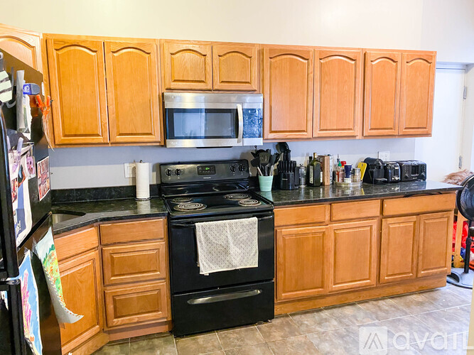 A kitchen with wooden cabinets and a black stove top oven.