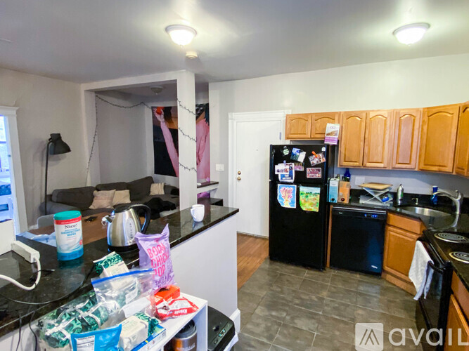 A kitchen with a black fridge and a black dishwasher.