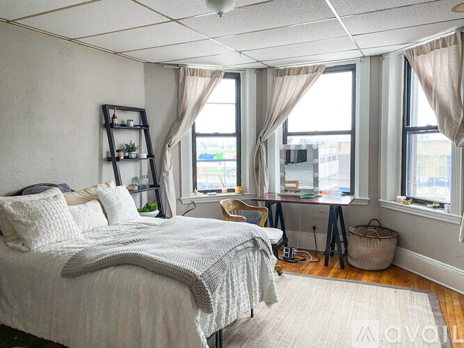 A bedroom with a large bed and a window with a view of the city.