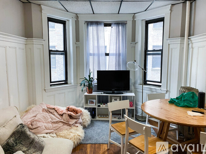 A living room with a couch, a chair, a table, and a television.