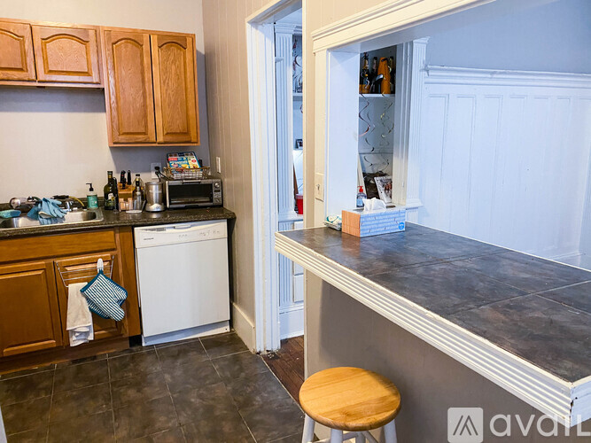 A kitchen with wooden cabinets and a white dishwasher.