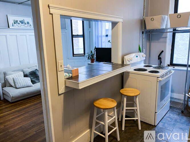 A kitchen with a white oven and wooden stools.