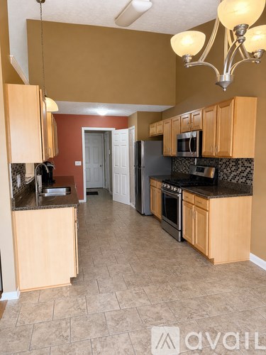 A kitchen with wooden cabinets and a black countertop.