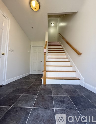 A staircase with wooden steps and a light on the wall.