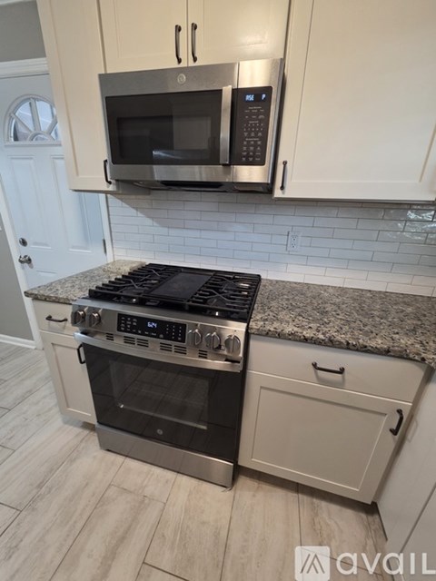 A kitchen with a stove top oven and microwave above it.