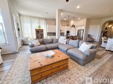 A spacious living room with a grey sofa set and a wooden coffee table.