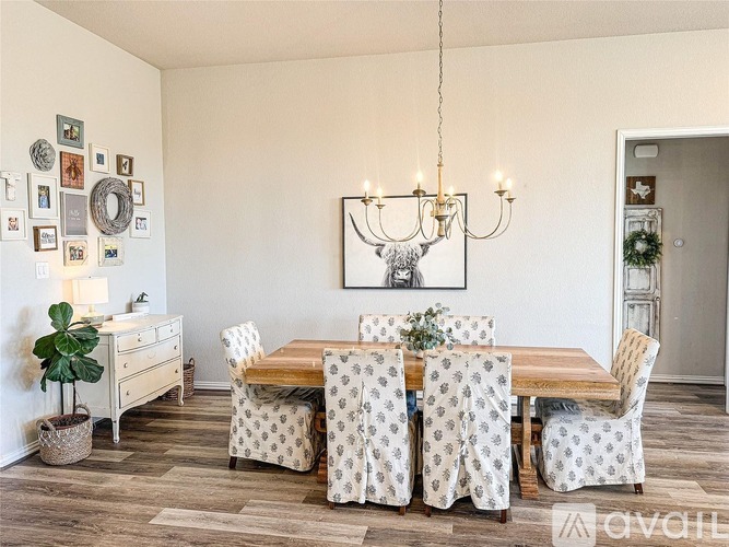 A dining room with a wooden table and chairs with patterned covers.