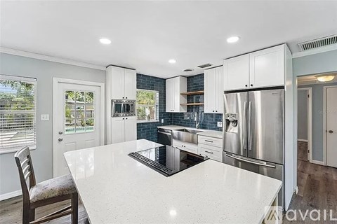 A kitchen with a white countertop and stainless steel appliances.