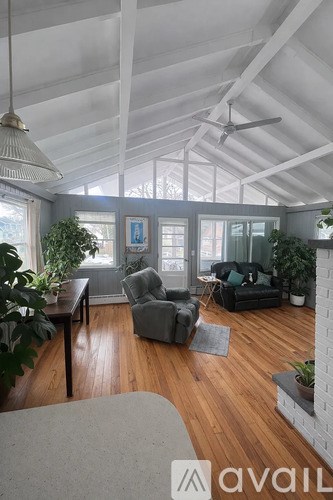 A living room with a grey couch and a wooden floor.