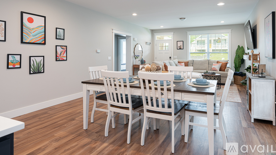 A dining room with a white table and chairs.