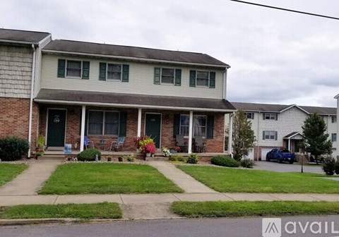 A house with a green door and a porch with a bench.