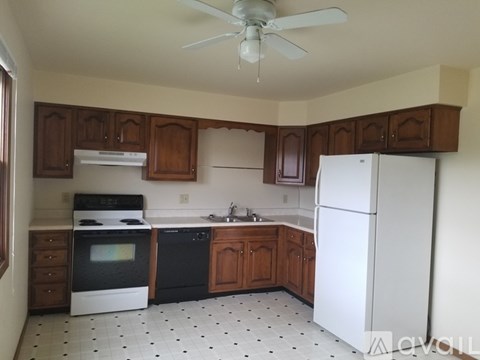 A kitchen with white appliances and wooden cabinets.