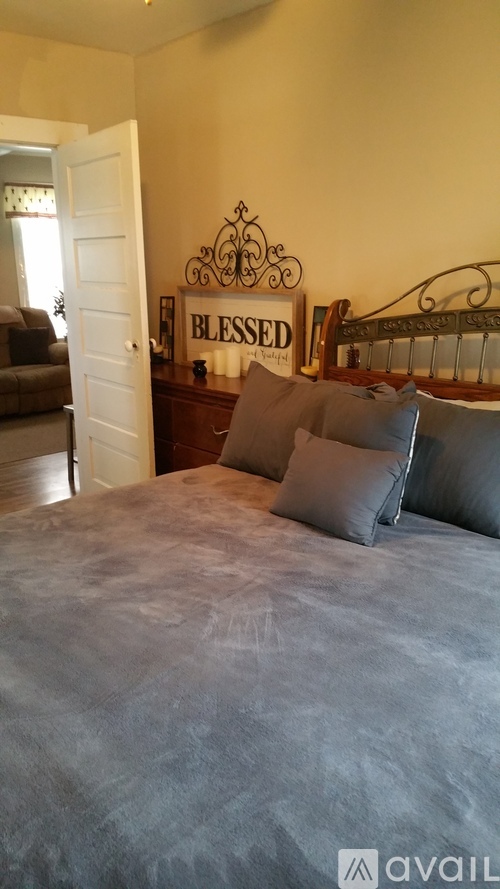 A bedroom with a bed, a couch, and a sign that says "BLESSED".