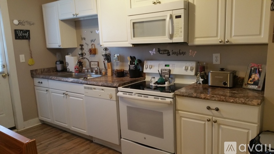 A kitchen with white cabinets and appliances.