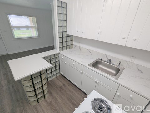 A kitchen with white cabinets and a washer and dryer.