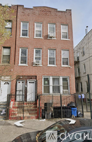 A brick building with a black car parked in front.