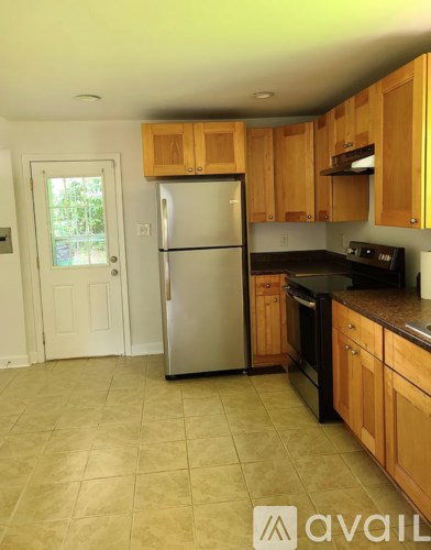 A kitchen with wooden cabinets and a refrigerator.