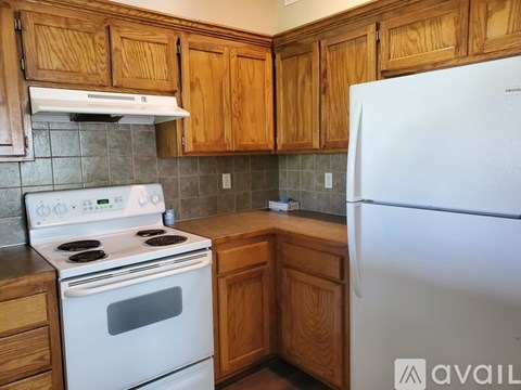 A kitchen with wooden cabinets and a white refrigerator.
