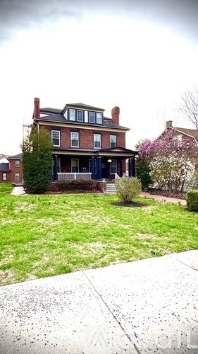 A red brick house with a black front door.