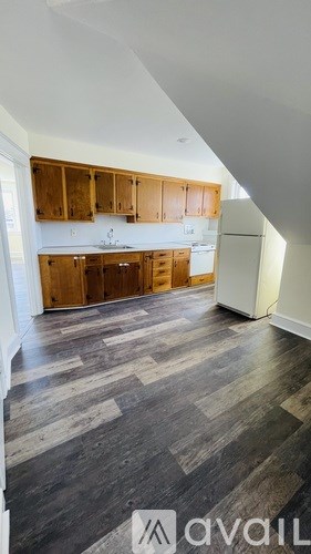A kitchen with wooden cabinets and a refrigerator.