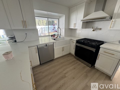 A kitchen with white cabinets and a black stove top oven.