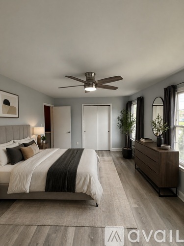 A bedroom with a large bed and a ceiling fan.
