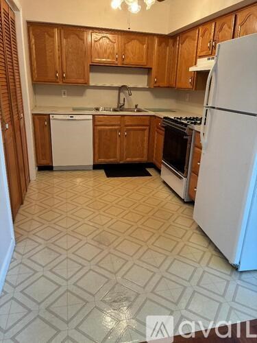 A kitchen with white appliances and wooden cabinets.