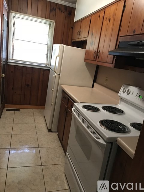 A kitchen with a stove top oven and a refrigerator.