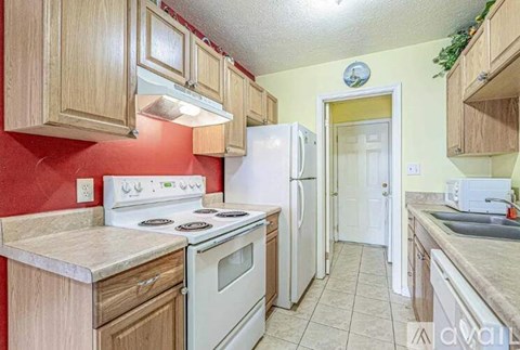 A kitchen with white appliances and wooden cabinets.