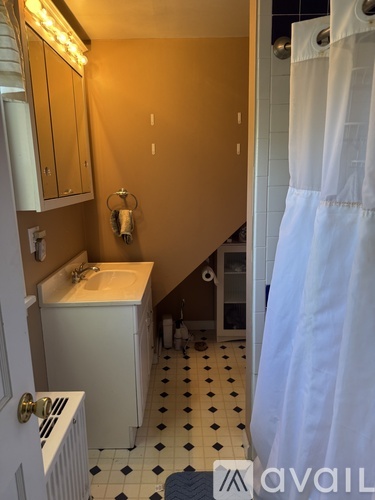 A bathroom with a white sink and a white shower curtain.