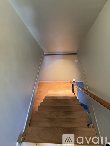 A wooden staircase with a metal railing.
