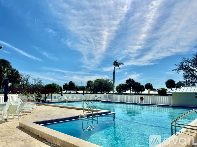 A large outdoor swimming pool with a sunny sky above.