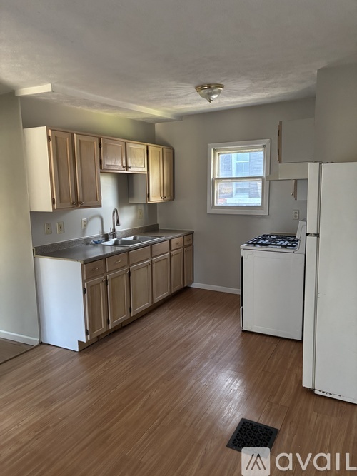 A kitchen with wooden cabinets and a white fridge.