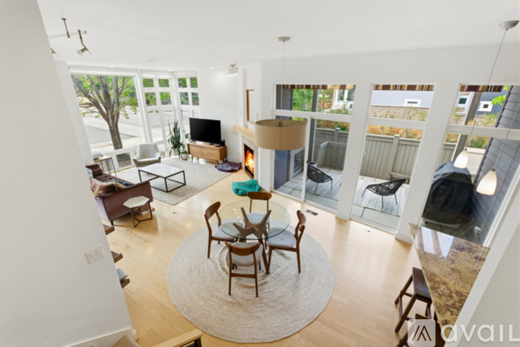 A living room with a fireplace and a dining table.